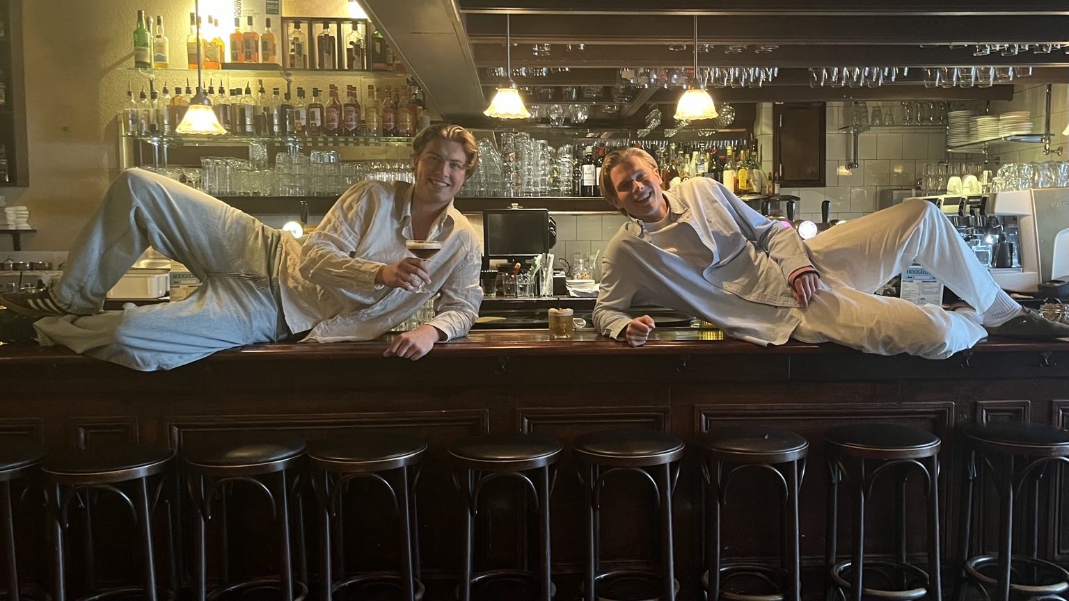 Karsten en Coen liggend op de bar bij Café Hooghoudt